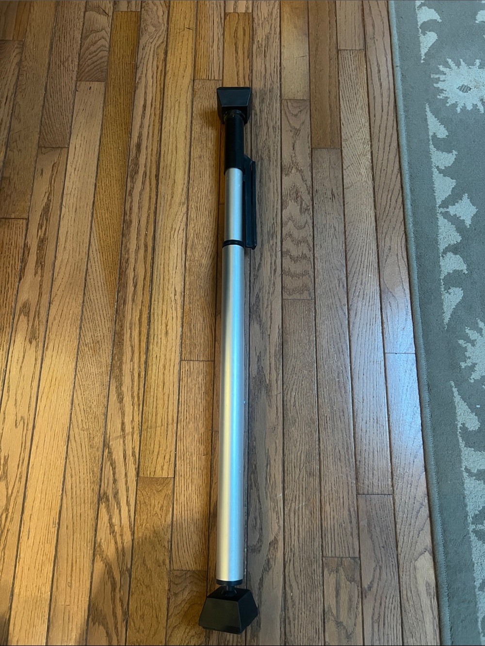 Portable adjustable door security bar to prevent doors from being forced open.